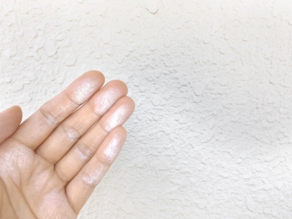 外壁のチョーキング現象で手に白い粉が付いている様子